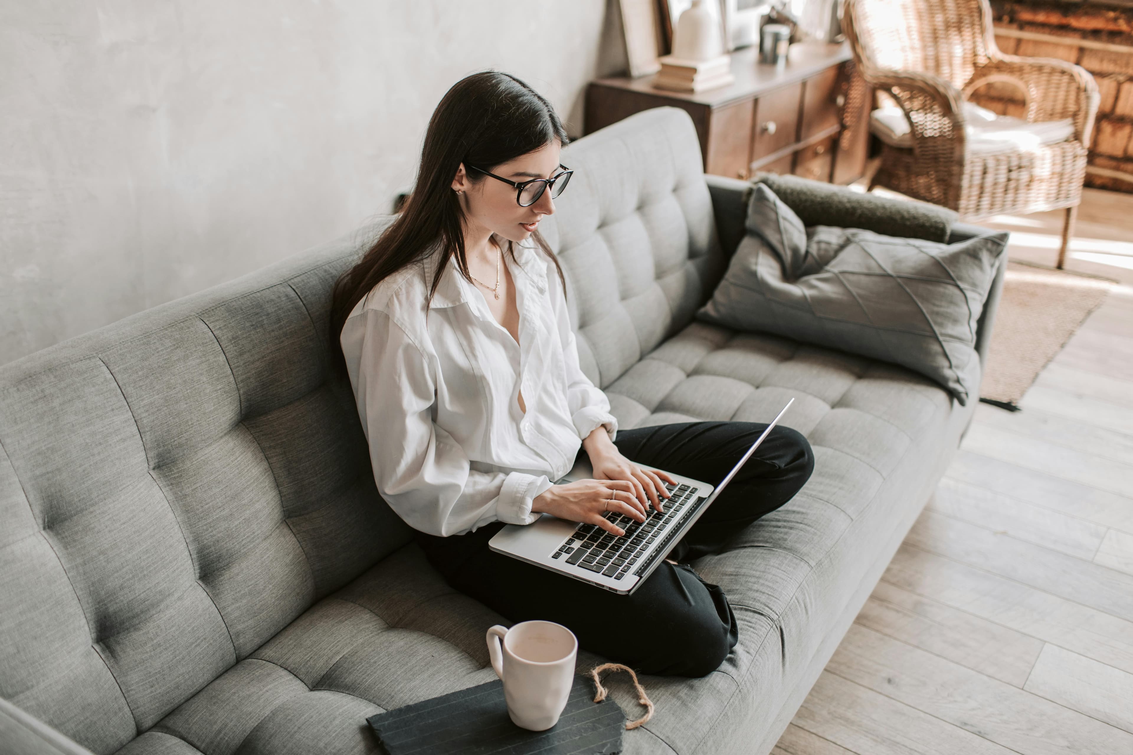 Woman sitting on sofa with laptop