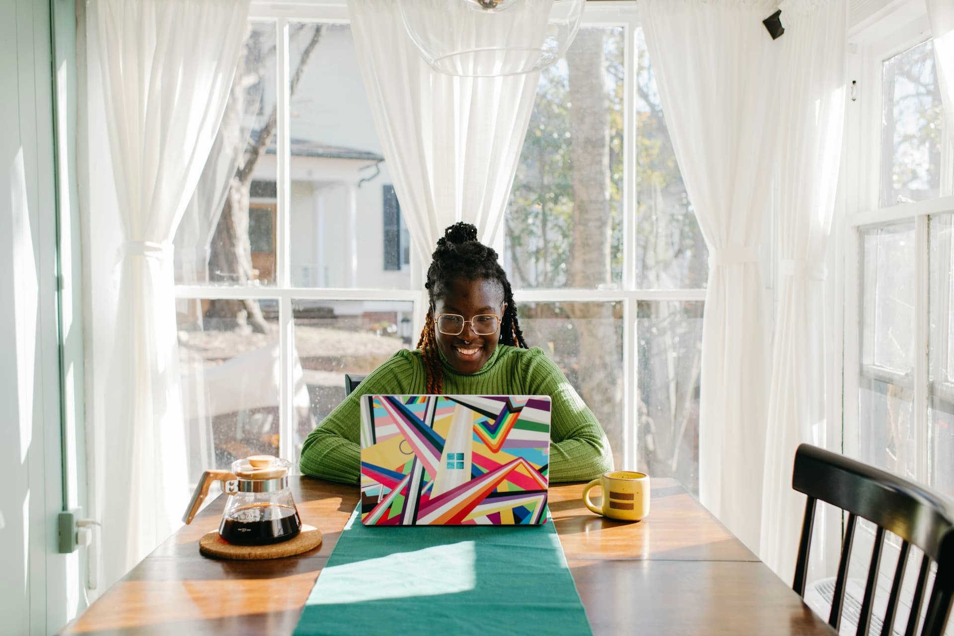 Woman at a table with her laptop, sending a 'hope you are well' email