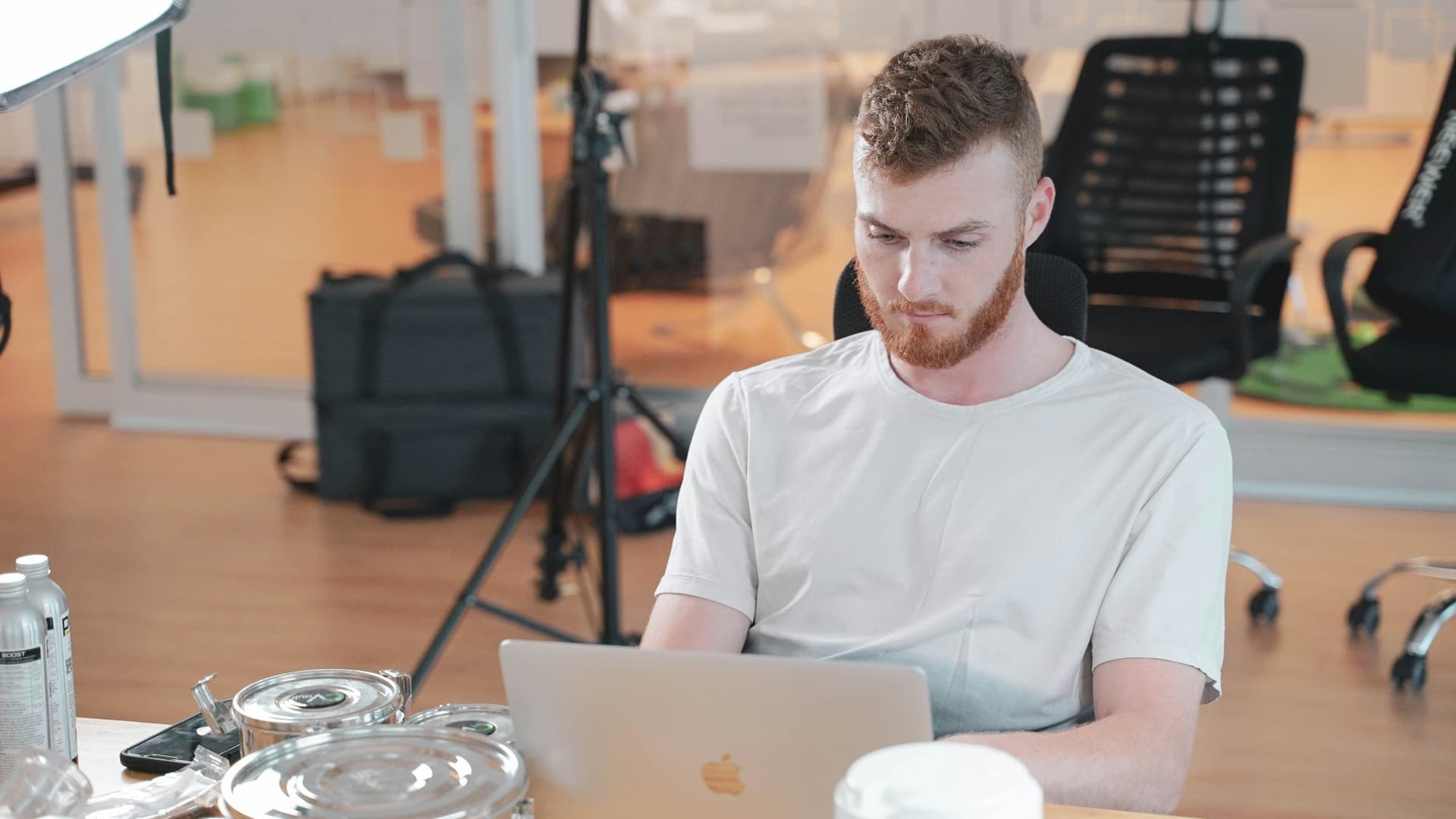 Man at Macbook, sending an email in an office, asking for something at work
