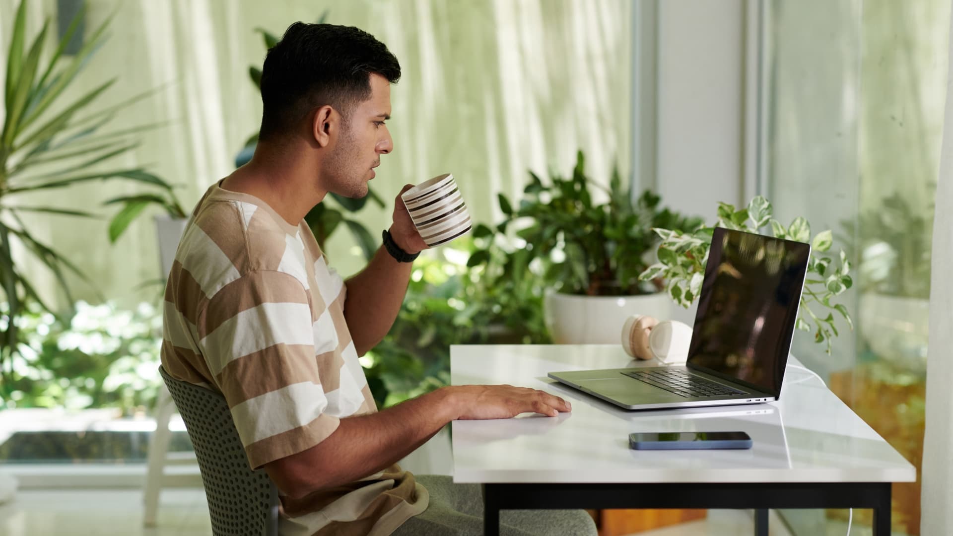 Man at his laptop, auto forwarding emails in Gmail