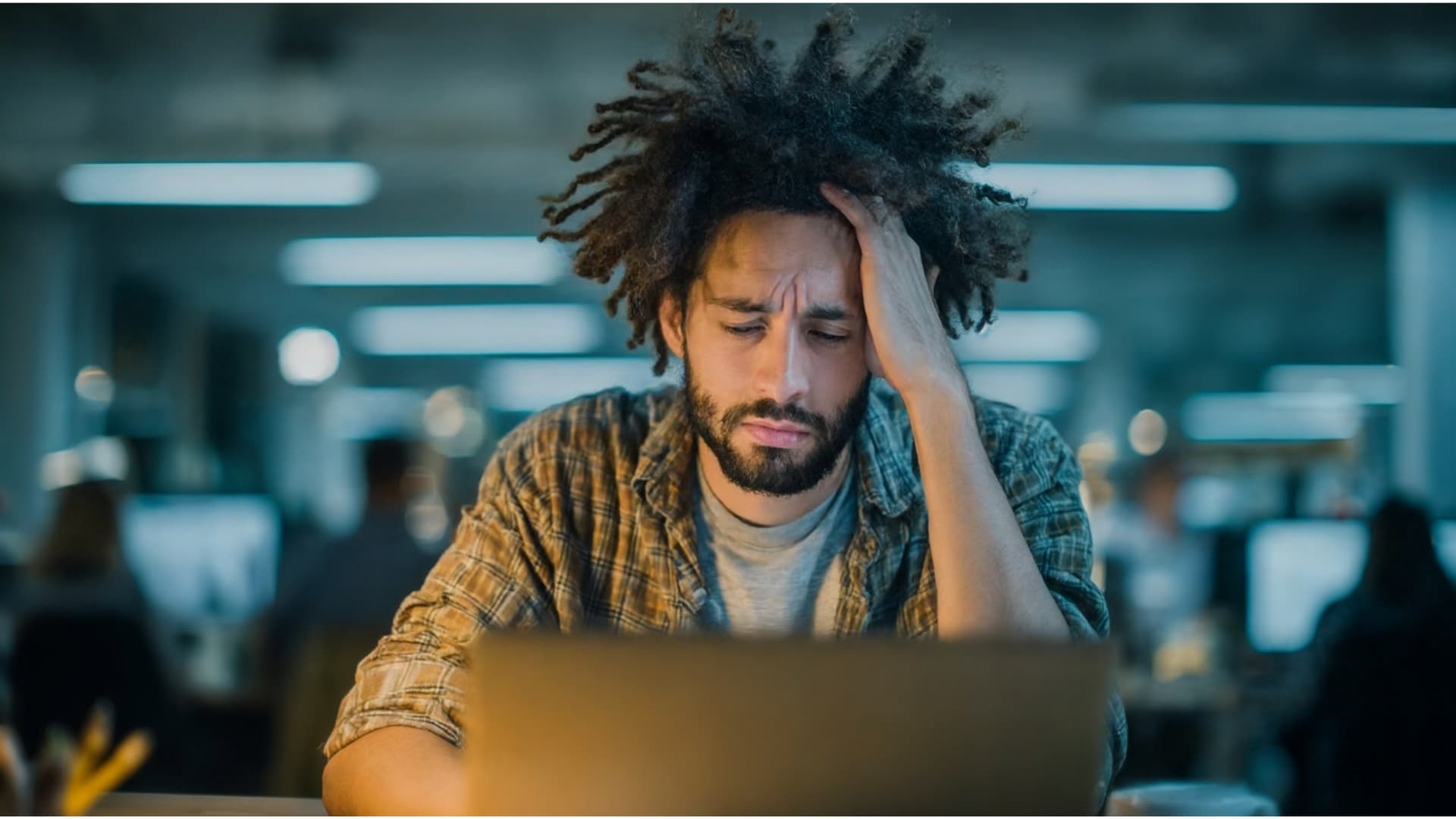 Man at laptop dealing with work anxiety