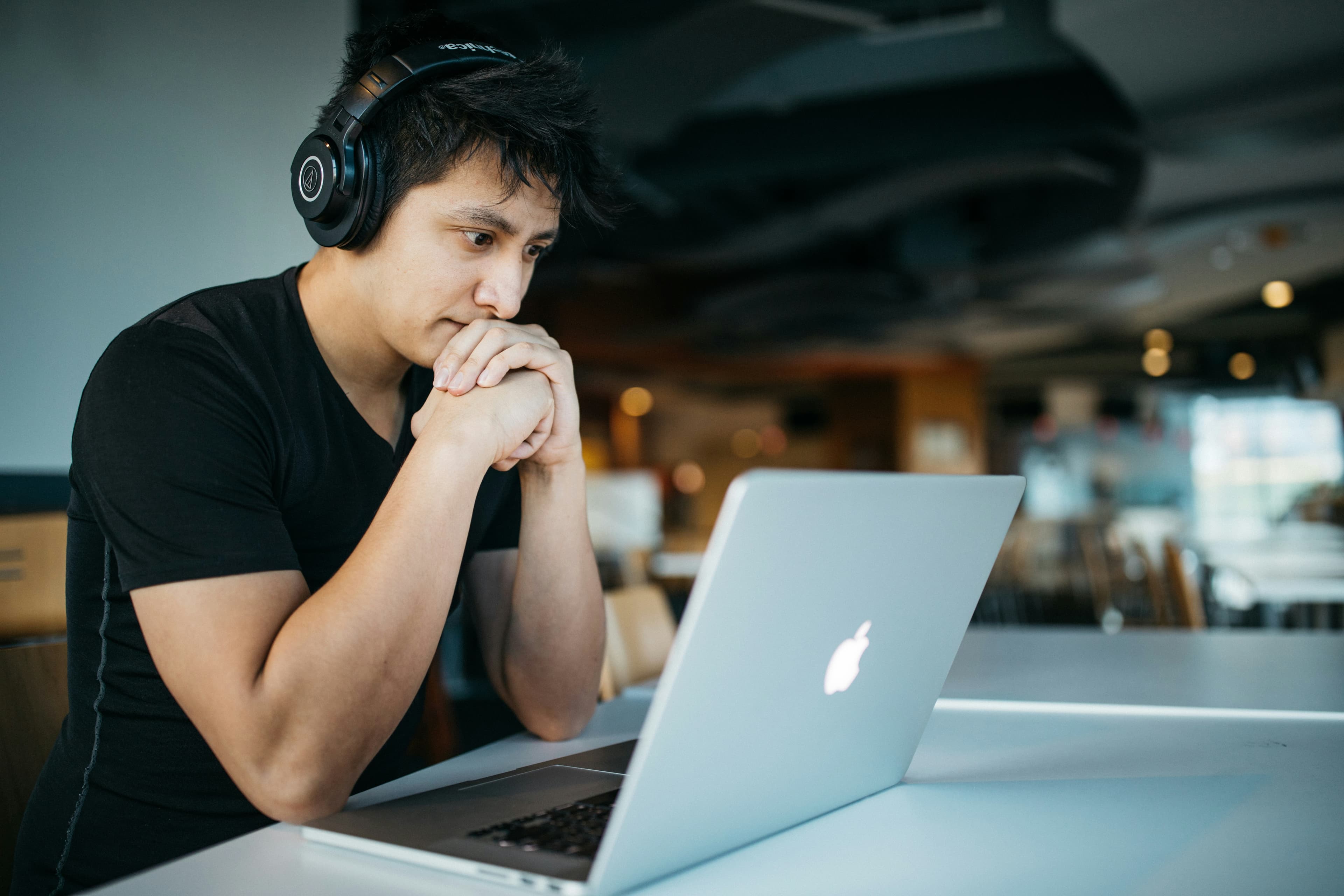 Man sitting at laptop wearing headphones