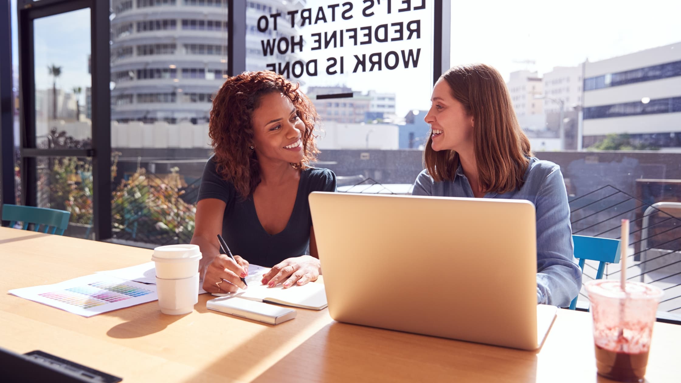 Women in an office sending a professional “What did you do last week” email to the team