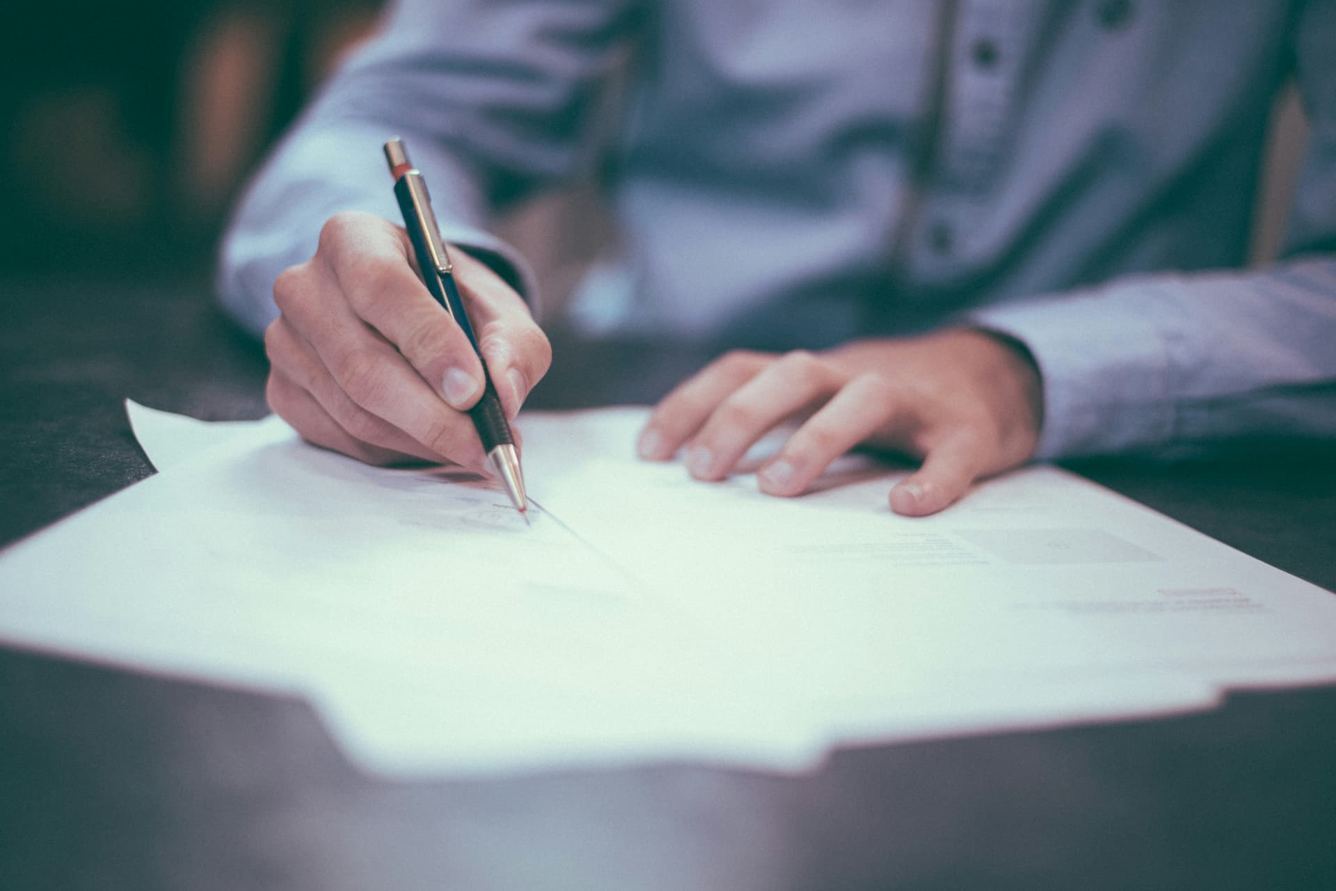 Man signing a document with a pen