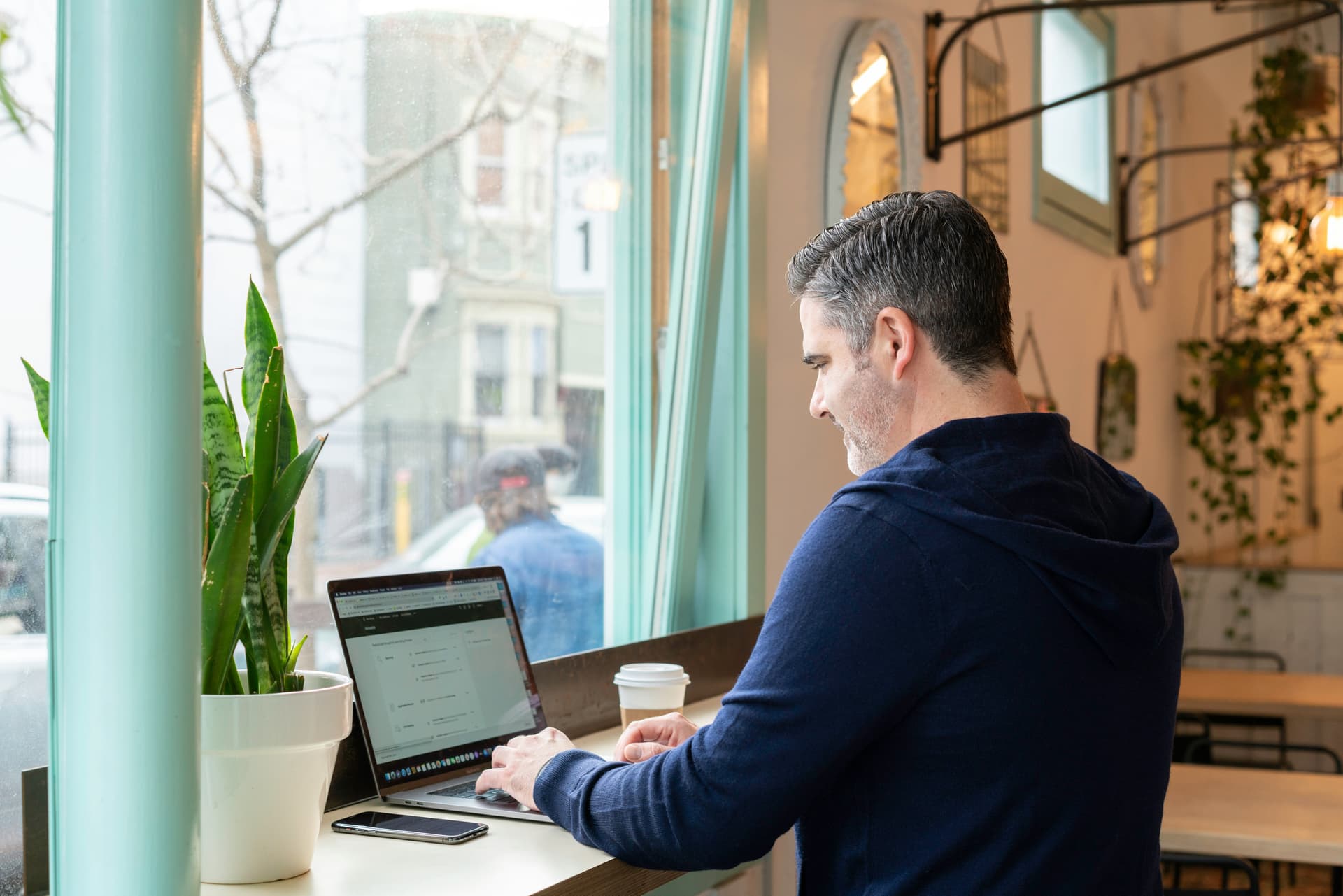 Man working at laptop in cafe