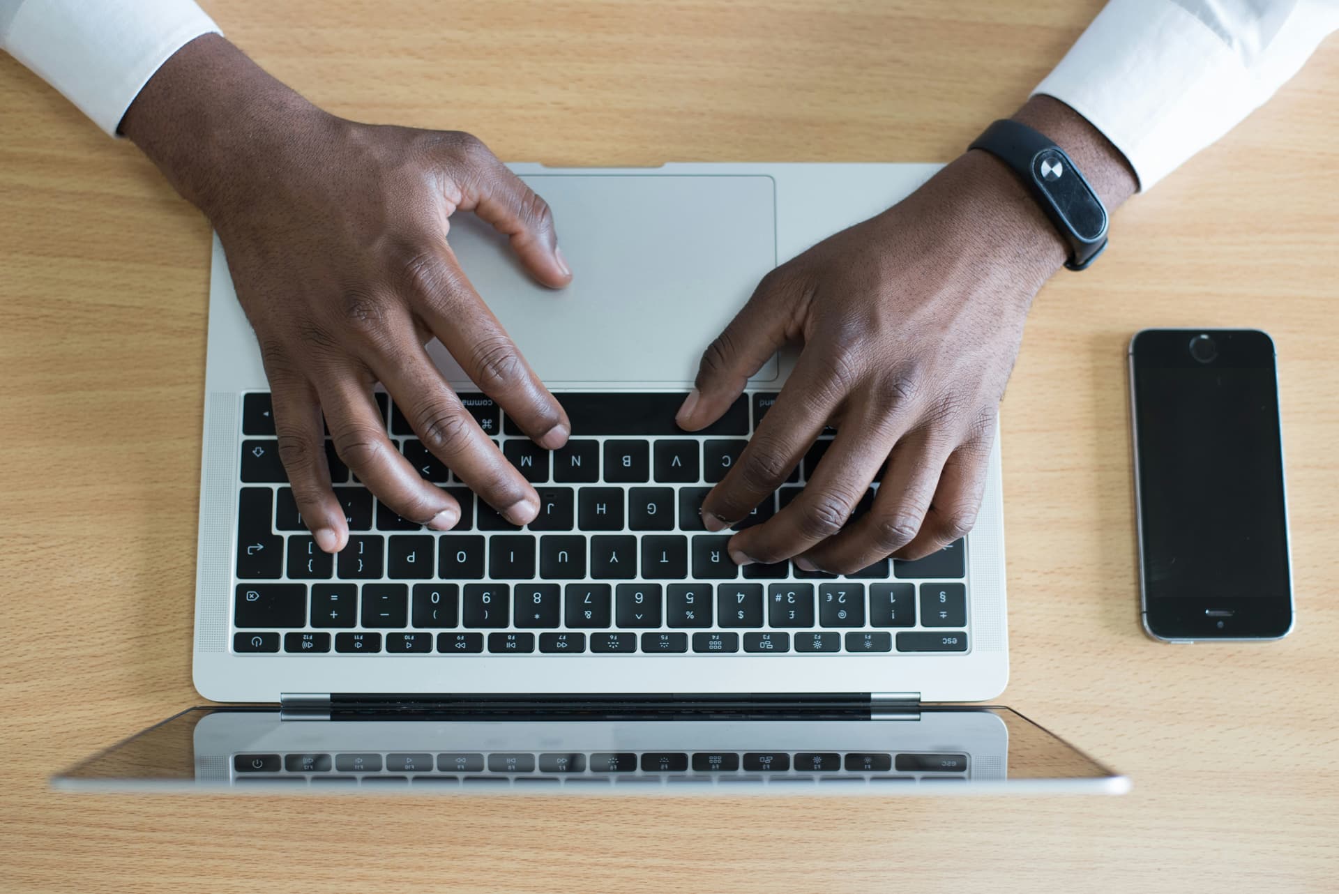 Man typing on laptop keyboard