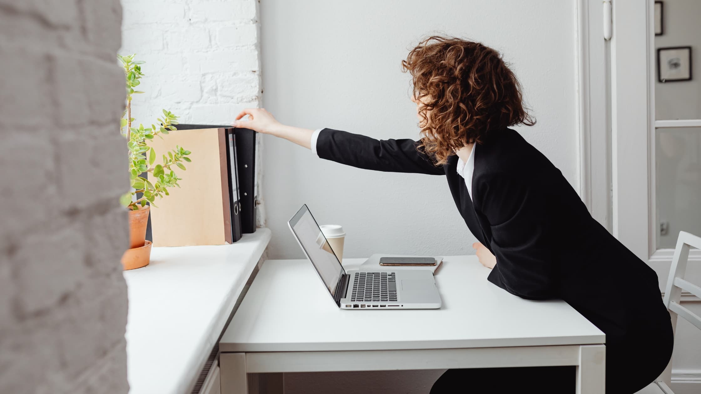 Woman reaching to attach a folder to an email